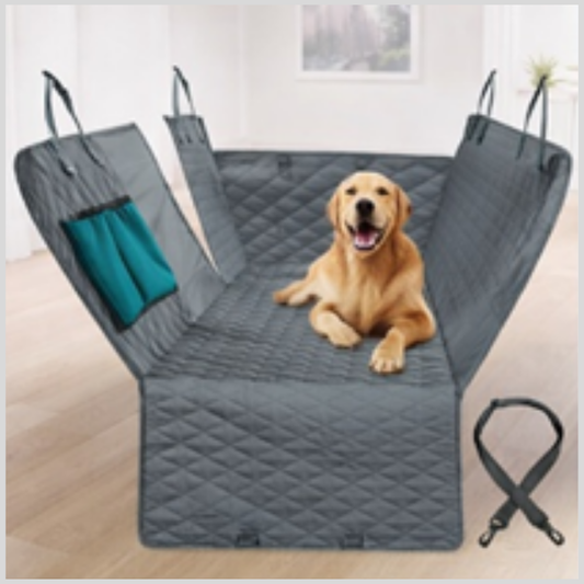 Dog sitting on a gray pet car seat cover with a teal pillow inside.